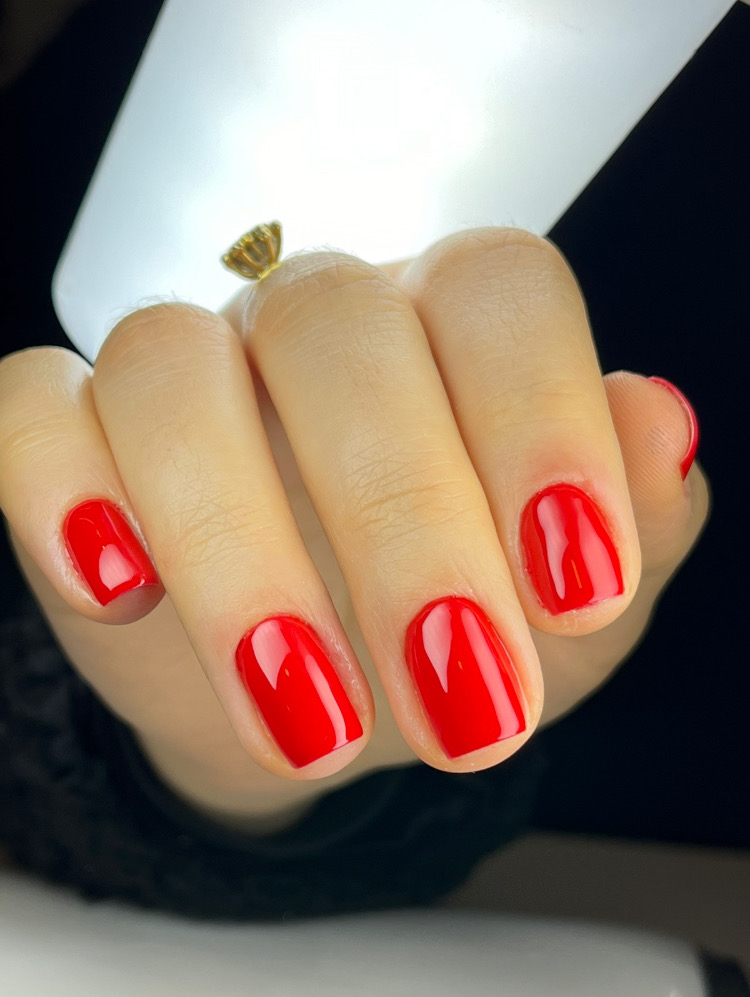 Unhas curtas quadradas com esmaltação vermelha brilhante